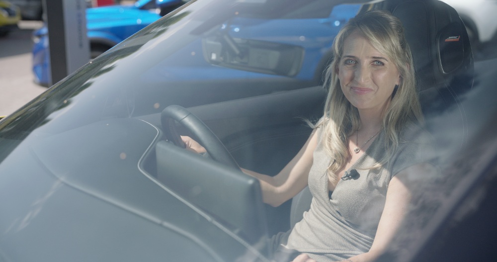 Woman in Car Woman sitting in car driver's seat viewed through windshield