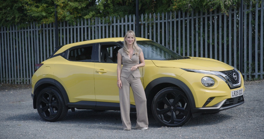 Nissan Juke Reveal Blonde woman posing beside a yellow Nissan Juke SUV outdoors