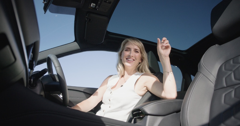 Woman With Car Keys Blonde woman holding car keys seated inside car with sunroof open