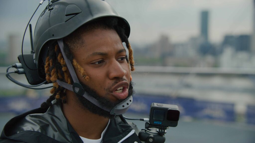 GoPro Helmet Shoot Man in helmet with GoPro camera against city skyline