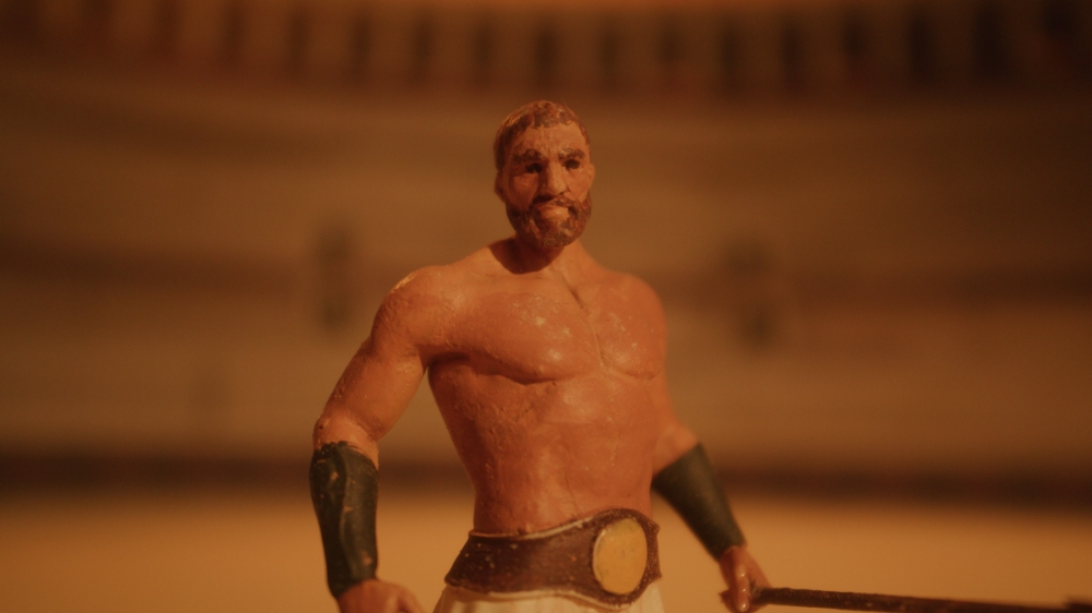 Tattooed gladiator warrior standing shirtless in Roman arena