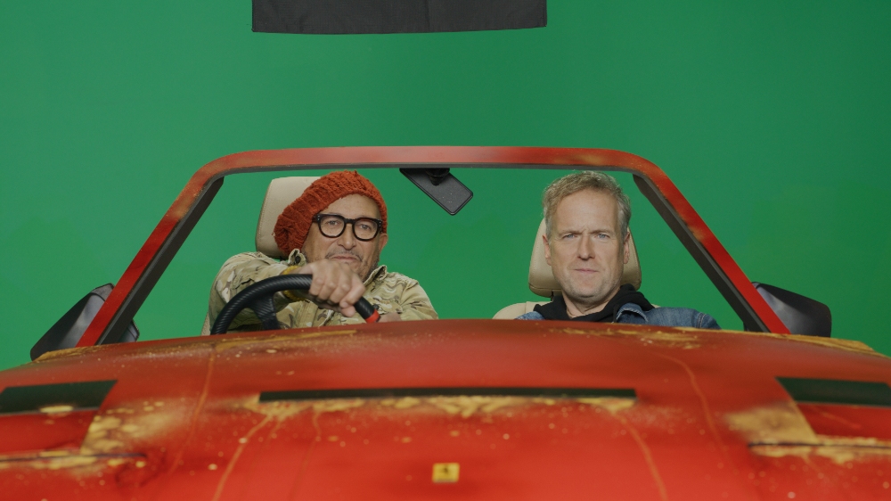 Two men in red Ferrari on Car SOS green screen set