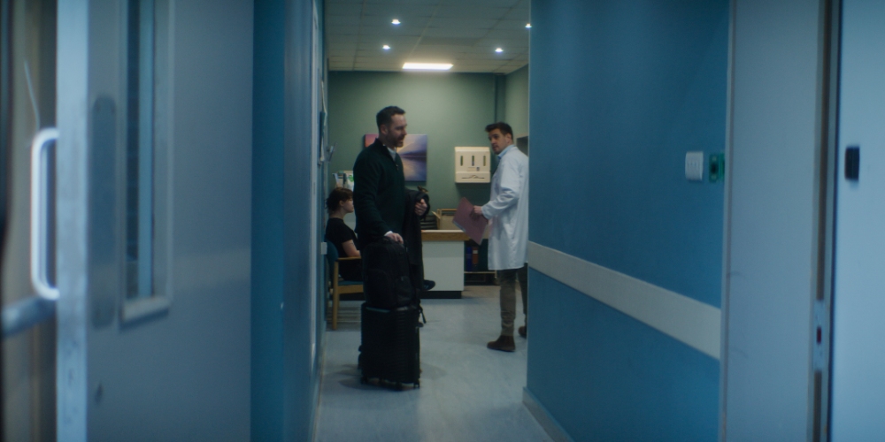 Hospital Corridor Meeting Two people talking in a blue hospital corridor
