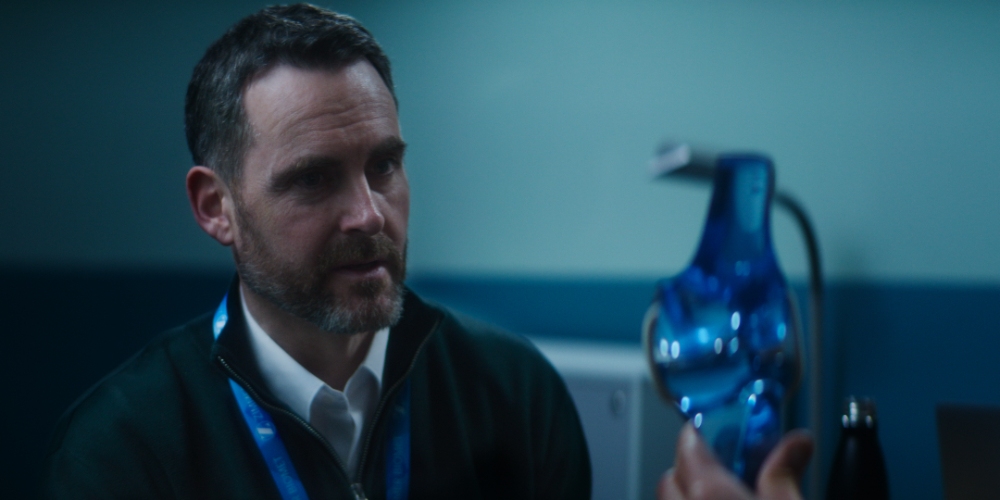 Man Holding Blue Vase Man in office holding a blue glass vase with lanyard
