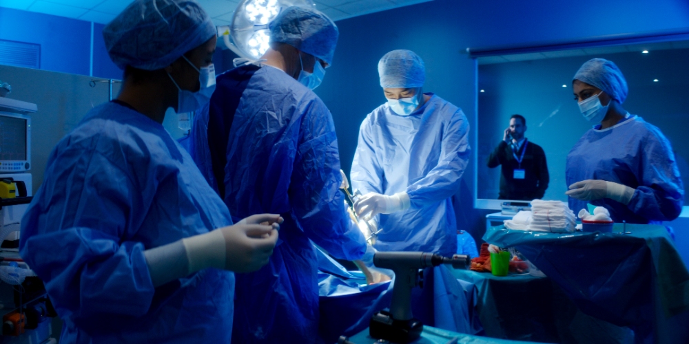 Operating Room Surgery Surgical team in blue scrubs performing an operation under bright lights