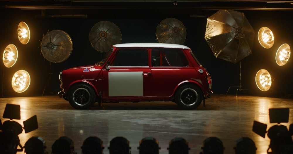 Red Mini Cooper Reveal Red classic Mini Cooper on studio stage under bright lights