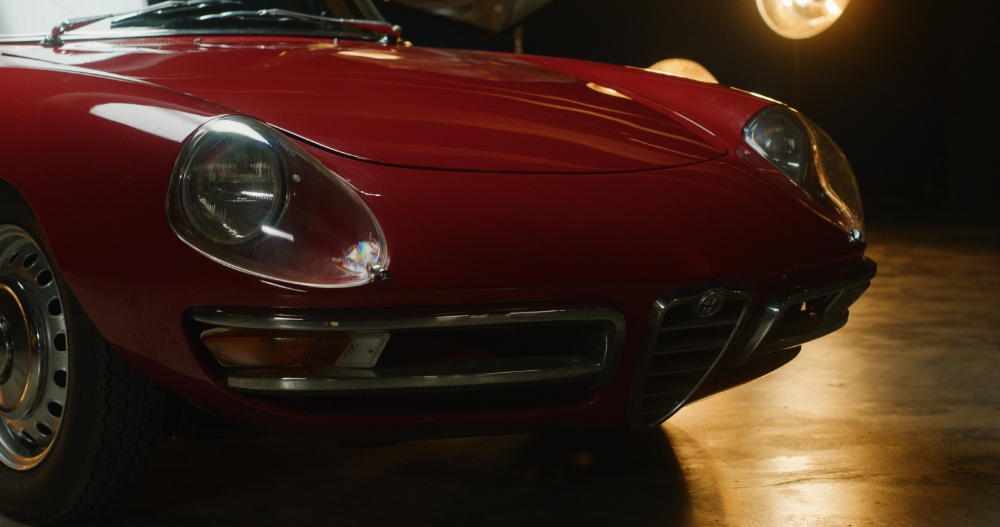 Classic Alfa Romeo Detail Red classic Alfa Romeo front headlight in warm studio light