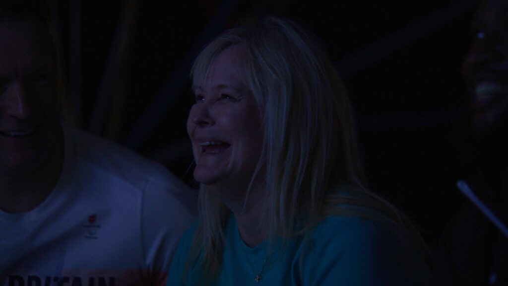 Emotional Audience Reaction Emotional blonde woman watching event in darkened venue