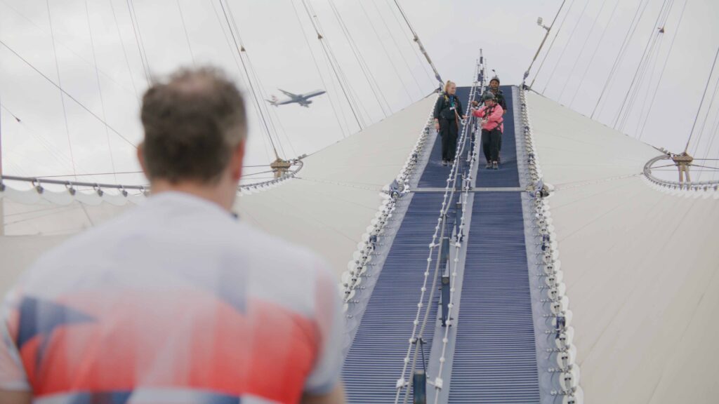 O2 Climb Overhead Plane Man watching group climb O2 Arena roof with plane overhead