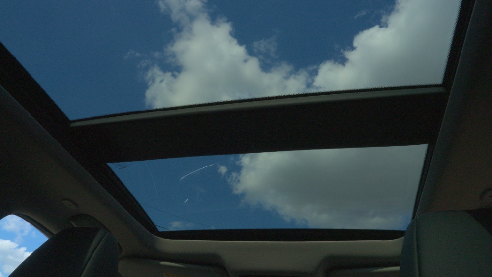 Car Panoramic Sunroof Panoramic sunroof view of blue sky and clouds from inside a car