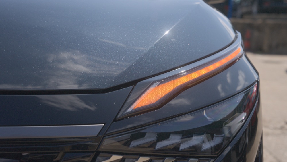 Car Headlight Detail Close-up of a sleek car headlight with amber DRL lighting