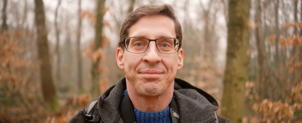 Man smiling in autumn forest during Kedrion Factor X film