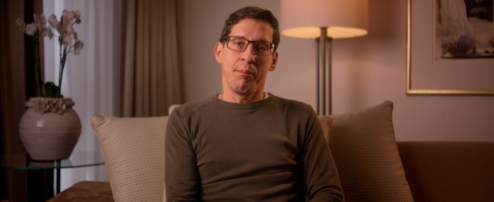 Man in glasses giving Kedrion Factor X testimonial indoors