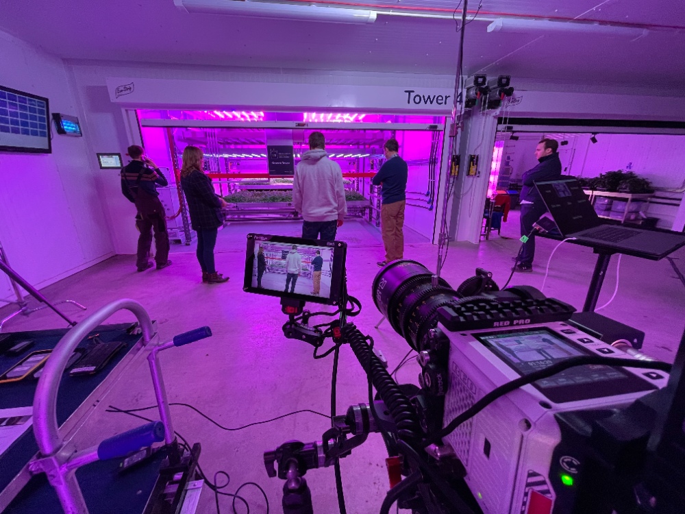 Vertical Farm Film Shoot Camera crew filming inside purple-lit vertical farm facility