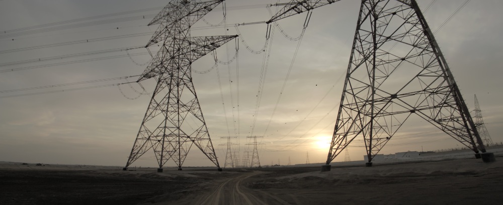 Desert Power Line Pylons High-voltage electricity pylons at dusk along a desert road