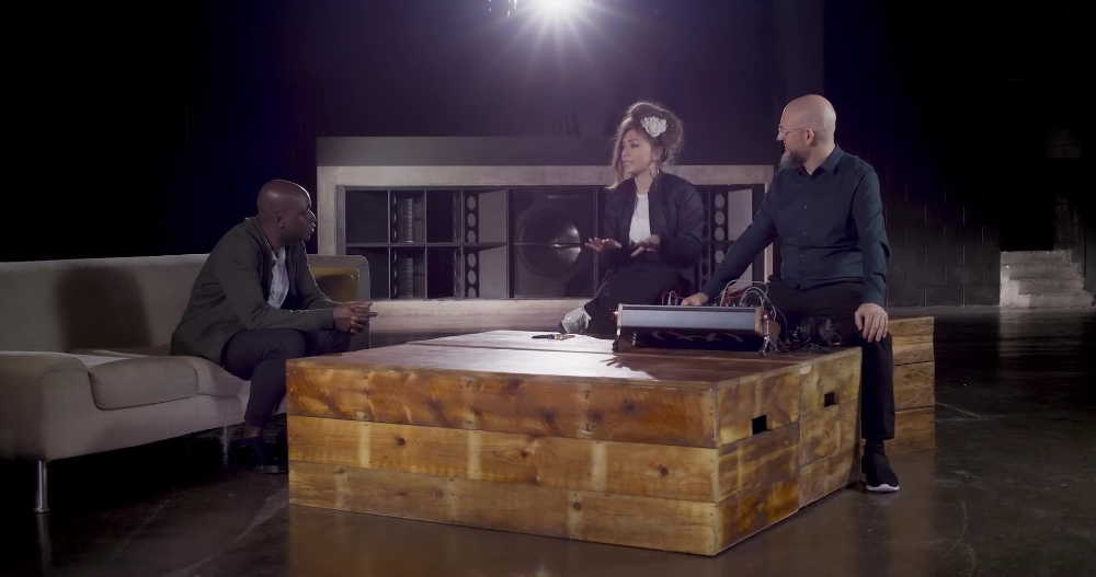 Studio Discussion Setup Three people in discussion around wooden coffee table on dark set