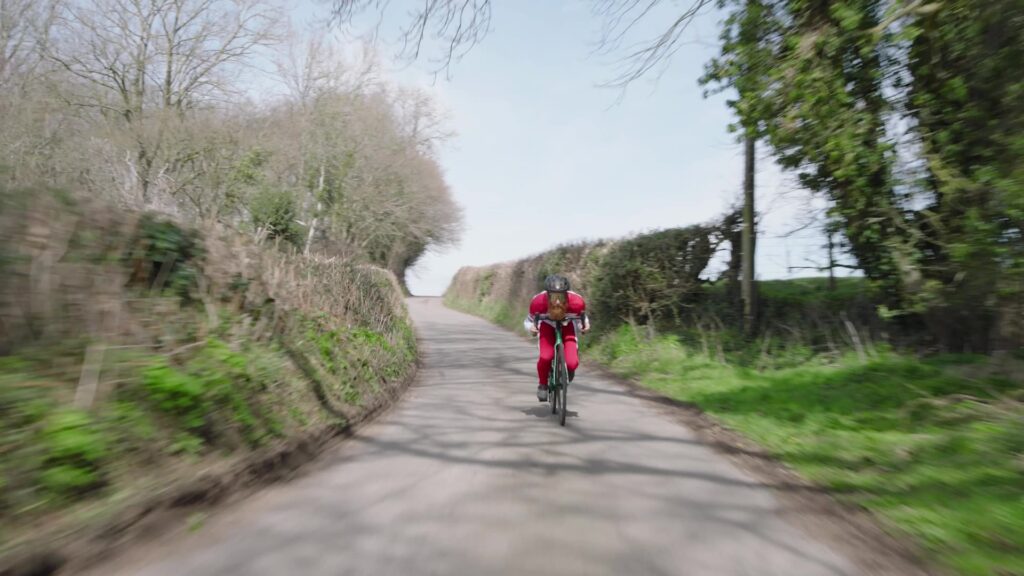 Cyclist in red kit riding along a rural country lane