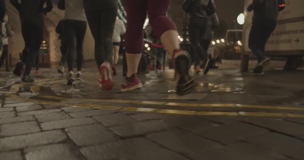 Night Group Run Low angle shot of group of runners' feet on cobblestones at night