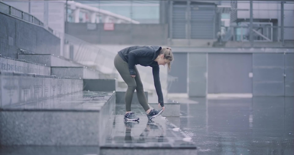 Runner Tying Shoes Athlete tying shoelaces on wet concrete steps outdoors