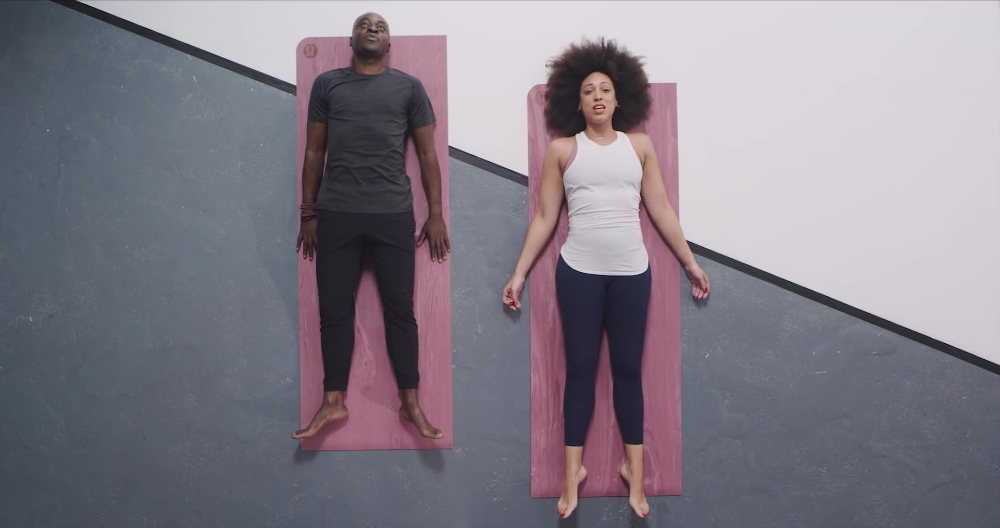 Overhead view of man and woman lying on pink yoga mats
