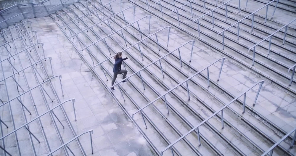 Athlete on Stadium Steps Aerial view of athlete running up stadium bleacher steps