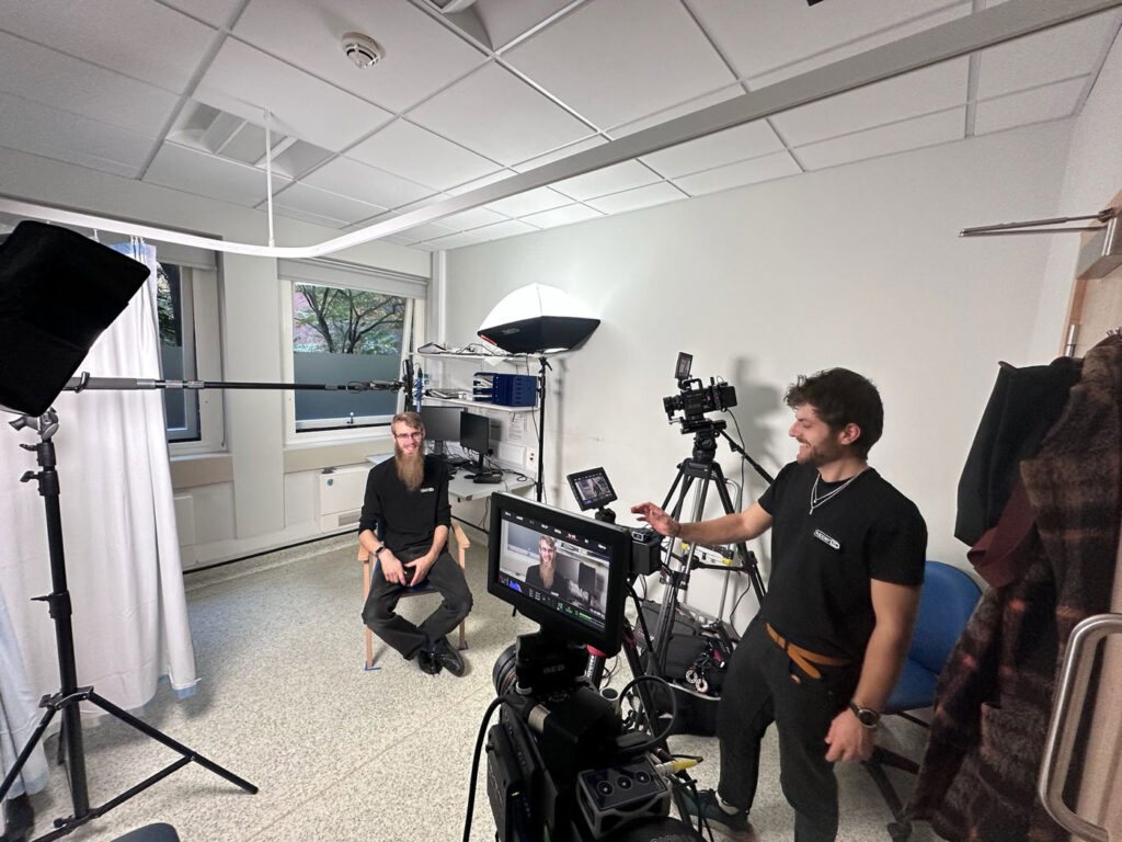 Studio Interview Setup Man being interviewed in front of a camera in a white room