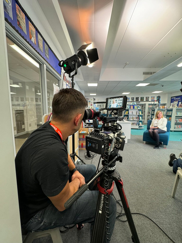 Library Interview Shoot Videographer filming an interview inside a library