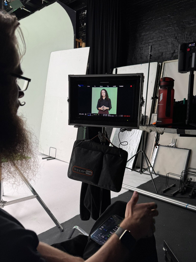 Green Screen Recording Director watching monitor of woman recorded in front of green screen