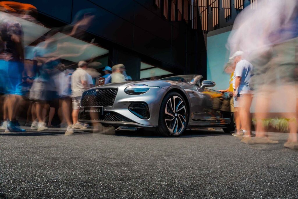Luxury Convertible at Event Silver luxury convertible car surrounded by crowd outdoors