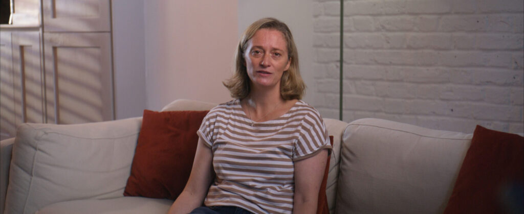 Woman in striped top sitting on sofa during interview