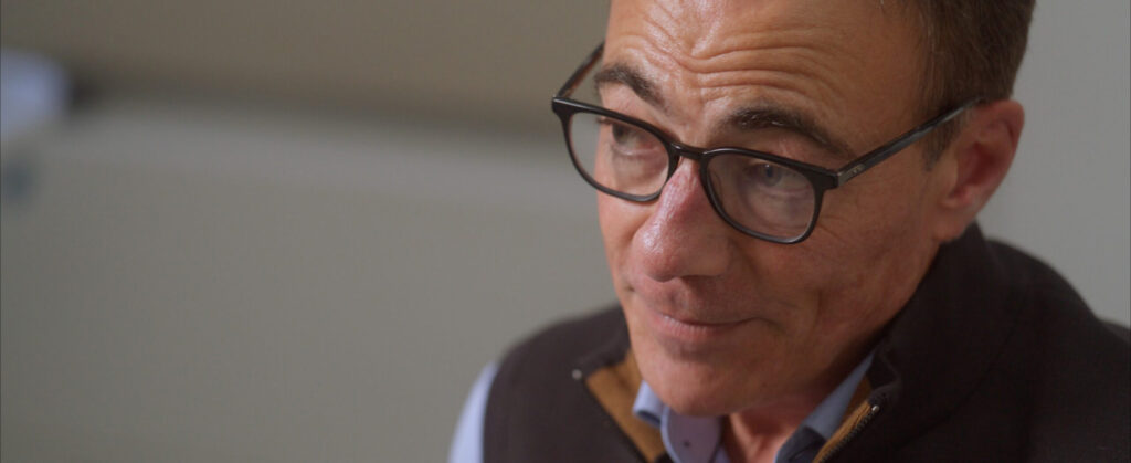 Man with glasses in thoughtful conversation, close-up portrait