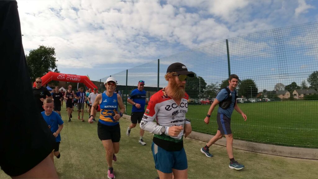 Runner crossing finish line at outdoor sports event