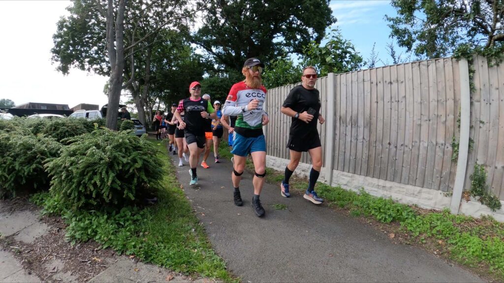 Group of runners jogging along a suburban pavement